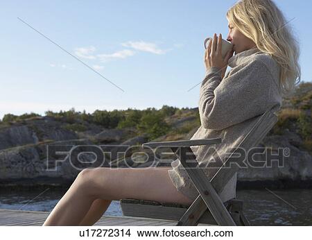 Picture - Young Woman relaxing on jetty.. Fotosearch