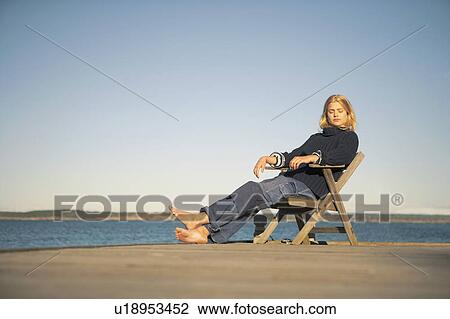Young Woman relaxing on jetty. View Large Photo Image Stock Image - Young Woman relaxing on jetty.. Fotosearch