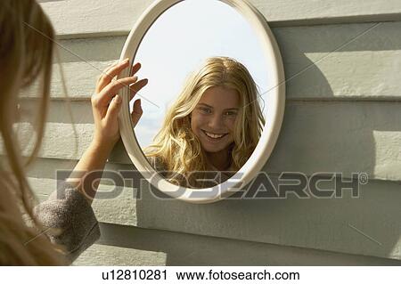 Young Woman Looking in Mirror outside. View Large Photo Image Stock Image - Young Woman Looking in Mirror outside.. Fotosearch