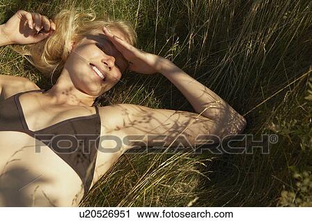 Young Woman lying in grass. View Large Photo Image Stock Image - Young Woman lying in grass.. Fotosearch