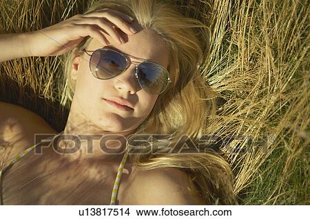 Young woman lying in long grass. View Large Photo Image Picture - Young woman lying in long grass.. Fotosearch
