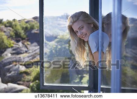 Stock Image - Young Woman Sitting in Long grass.. Fotosearch