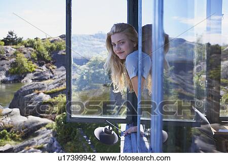 Stock Image - Young Woman Sitting in Long grass.. Fotosearch