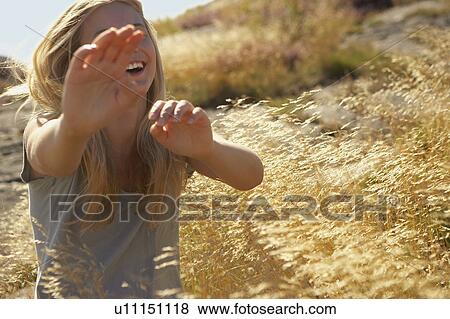 Young Woman Sitting in Long grass. View Large Photo Image Stock Photo - Young Woman Sitting in Long grass.. Fotosearch