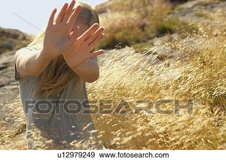 Stock Photo - Young Woman Sitting in Long grass.. Fotosearch