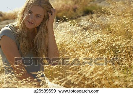 Young Woman Sitting in Long grass. View Large Photo Image Stock Photo - Young Woman Sitting in Long grass.. Fotosearch