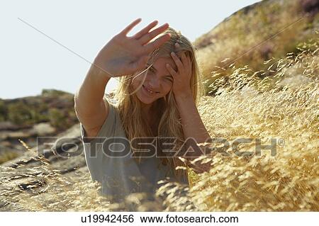 Young Woman Sitting in Long grass. View Large Photo Image Stock Photograph - Young Woman Sitting in Long grass.. Fotosearch