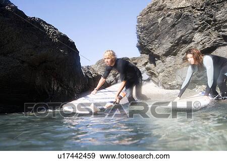 Couple in the water with surfboards. View Large Photo Image Stock Photo - Couple in the water with surfboards.. Fotosearch