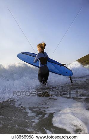 Female surfer running into the surf. View Large Photo Image Stock Photo - Female surfer running into the surf.. Fotosearch