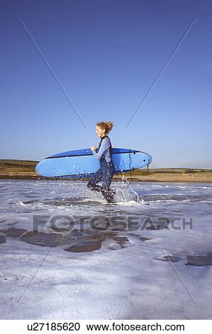Female surfer running into the water. View Large Photo Image Stock Image - Female surfer running into the water.. Fotosearch