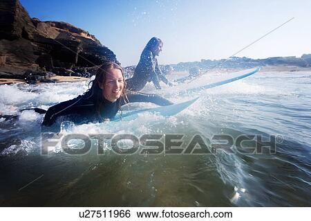 Four people in the water with surfboards smiling. View Large Photo Image Stock Photograph - Four people in the water with surfboards smiling.. Fotosearch