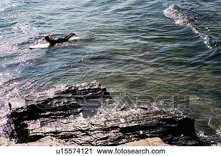 Woman lying on surfboard in the water. View Large Photo Image Stock Image - Woman lying on surfboard in the water.. Fotosearch