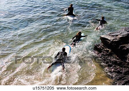 Four people on surfboards in the water. View Large Photo Image Stock Photography - Four people on surfboards in the water.. Fotosearch