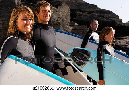Four people standing with surfboards smiling. View Large Photo Image Stock Photography - Four people standing with surfboards smiling.. Fotosearch