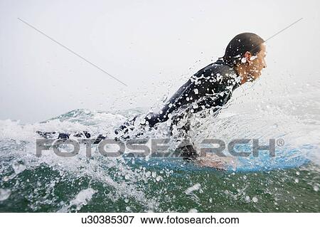 Man on surfboard splashing in the water. View Large Photo Image Stock Photo - Man on surfboard splashing in the water.. Fotosearch