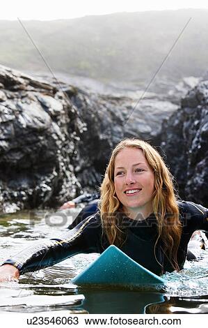 Three people lying on surfboards in the water smiling. View Large Photo Image Stock Image - Three people lying on surfboards in the water smiling.. Fotosearch