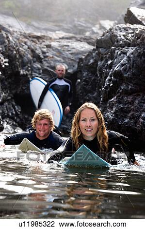 Three people with surfboards smiling. View Large Photo Image Stock Image - Three people with surfboards smiling.. Fotosearch