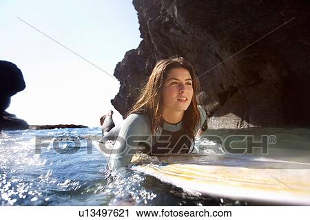 Woman lying on surfboard in the water. View Large Photo Image Stock Image - Woman lying on surfboard in the water.. Fotosearch
