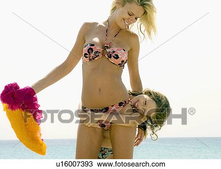 Stock Image - Woman and young girl being playful at the beach smiling.. Fotosearch