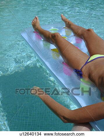 Woman floating in a pool. View Large Photo Image Picture - Woman floating in a pool.. Fotosearch