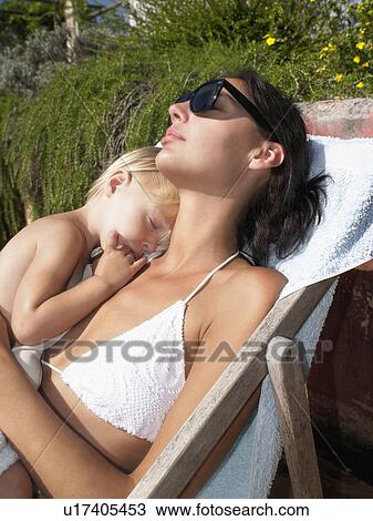 Woman lying with a sleeping baby in a deck chair. View Large Photo Image Stock Image - Woman lying with a sleeping baby in a deck chair.. Fotosearch