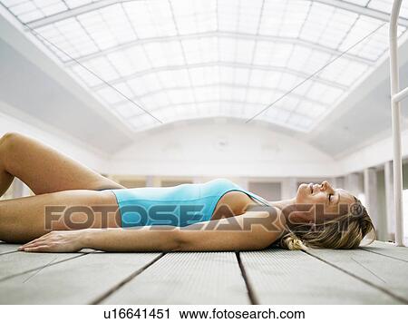 Woman wearing bathing suit, lying on decking, side view View Large Photo Image Stock Image - Woman wearing bathing suit, lying on decking, side view. Fotosearch