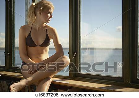 Young woman by windows of beach house. View Large Photo Image Stock Photograph - Young woman by windows of beach house.. Fotosearch