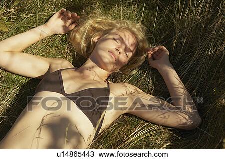 Young Woman lying in grass. View Large Photo Image Stock Image - Young Woman lying in grass.. Fotosearch