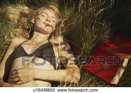 Young woman lying in long grass. View Large Photo Image Stock Photography - Young woman lying in long grass.. Fotosearch