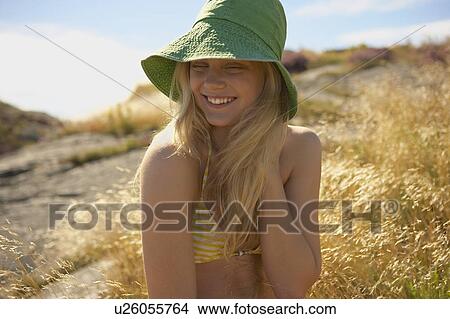 Young Woman Sitting in Long grass. View Large Photo Image Picture - Young Woman Sitting in Long grass.. Fotosearch