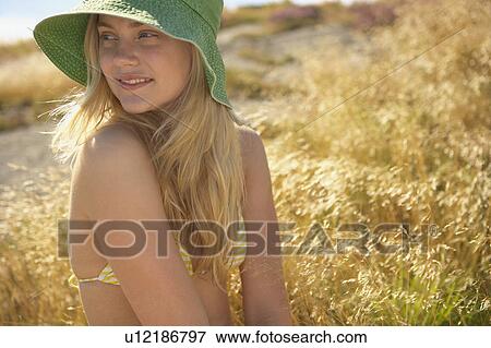 Stock Photo - Young Woman Sitting in Long grass.. Fotosearch