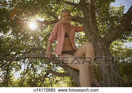 Young Woman sitting in tree. View Large Photo Image Stock Photography - Young Woman sitting in tree.. Fotosearch