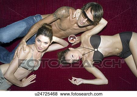 Three people on a blanket with a drink View Large Photo Image Stock Photo - Three people on a blanket with a drink. Fotosearch
