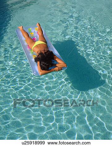 Woman floating in a pool on her stomach. View Large Photo Image Stock Photo - Woman floating in a pool on her stomach.. Fotosearch