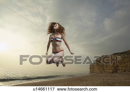 Woman jumping with beach background. View Large Photo Image Stock Photo - Woman jumping with beach background.. Fotosearch