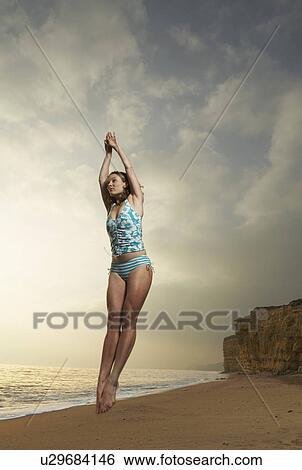 Woman jumping with beach background. View Large Photo Image Stock Photograph - Woman jumping with beach background.. Fotosearch