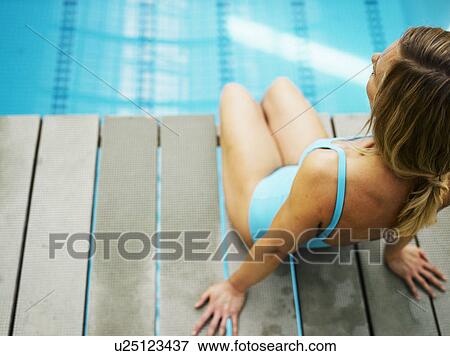 Woman sitting on diving board, elevated view View Large Photo Image Stock Photo - Woman sitting on diving board, elevated view. Fotosearch