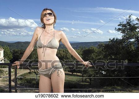 Woman standing outdoors in a bikini View Large Photo Image Stock Image - Woman standing outdoors in a bikini. Fotosearch