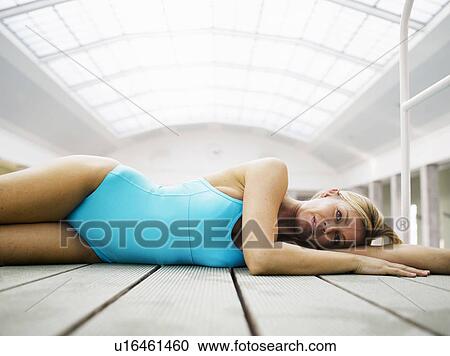 Woman wearing bathing suit, lying on decking, portrait View Large Photo Image Stock Image - Woman wearing bathing suit, lying on decking, portrait. Fotosearch