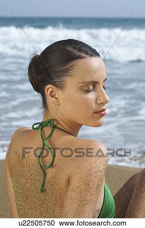 Young woman in bikini on beach sandy back eyes closed sea in background. View Large Photo Image Stock Image - Young woman in bikini on beach sandy back eyes closed sea in background.. Fotosearch