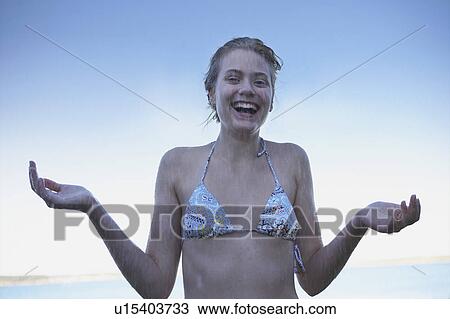 Stock Image - Young Woman in rain wearing bikini.. Fotosearch