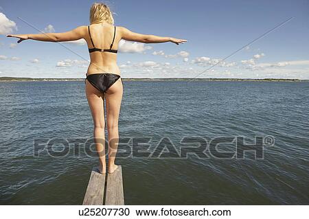 Stock Image - Young woman on diving platform.. Fotosearch