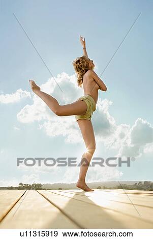 Young woman stretching on a terrace. View Large Photo Image Stock Photo - Young woman stretching on a terrace.. Fotosearch