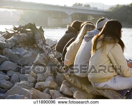 Group of friends sitting on tree View Large Photo Image Stock Photograph - Group of friends sitting on tree. Fotosearch