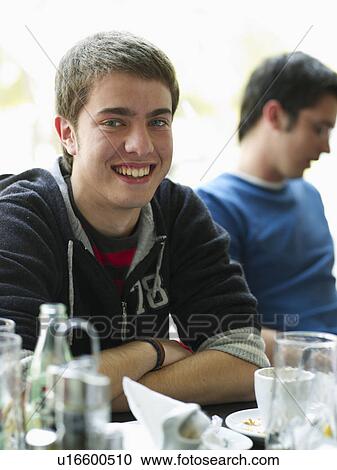 Portrait of teenage male sitting in cafe View Large Photo Image Stock Image - Portrait of teenage male sitting in cafe. Fotosearch
