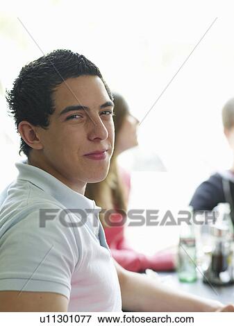 Stock Photo - Portrait of teenage male sitting in cafe. Fotosearch