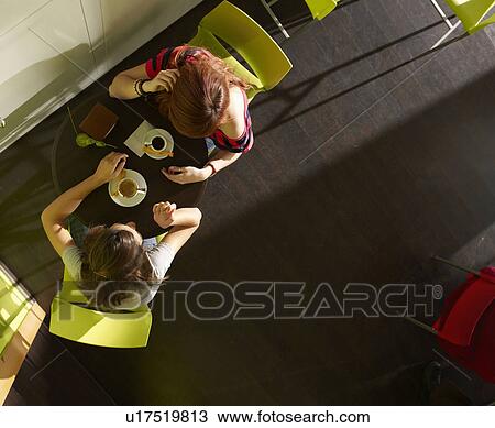 Stock Image - Two teenagers talking in cafe. Fotosearch