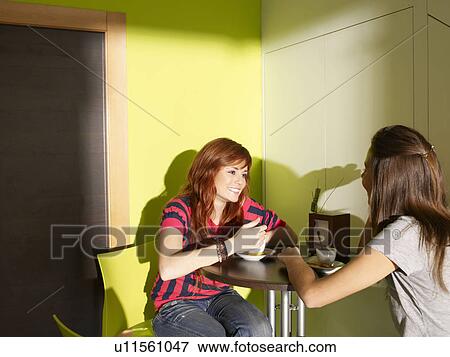 Stock Photo - Two teenagers talking in cafe. Fotosearch