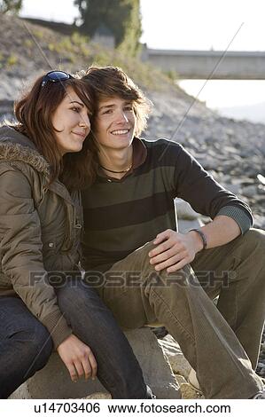 Stock Photograph - Young couple sitting together. Fotosearch