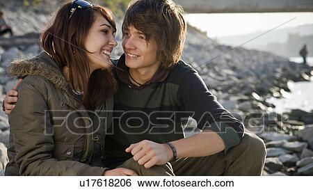 Stock Photograph - Young couple sitting together. Fotosearch